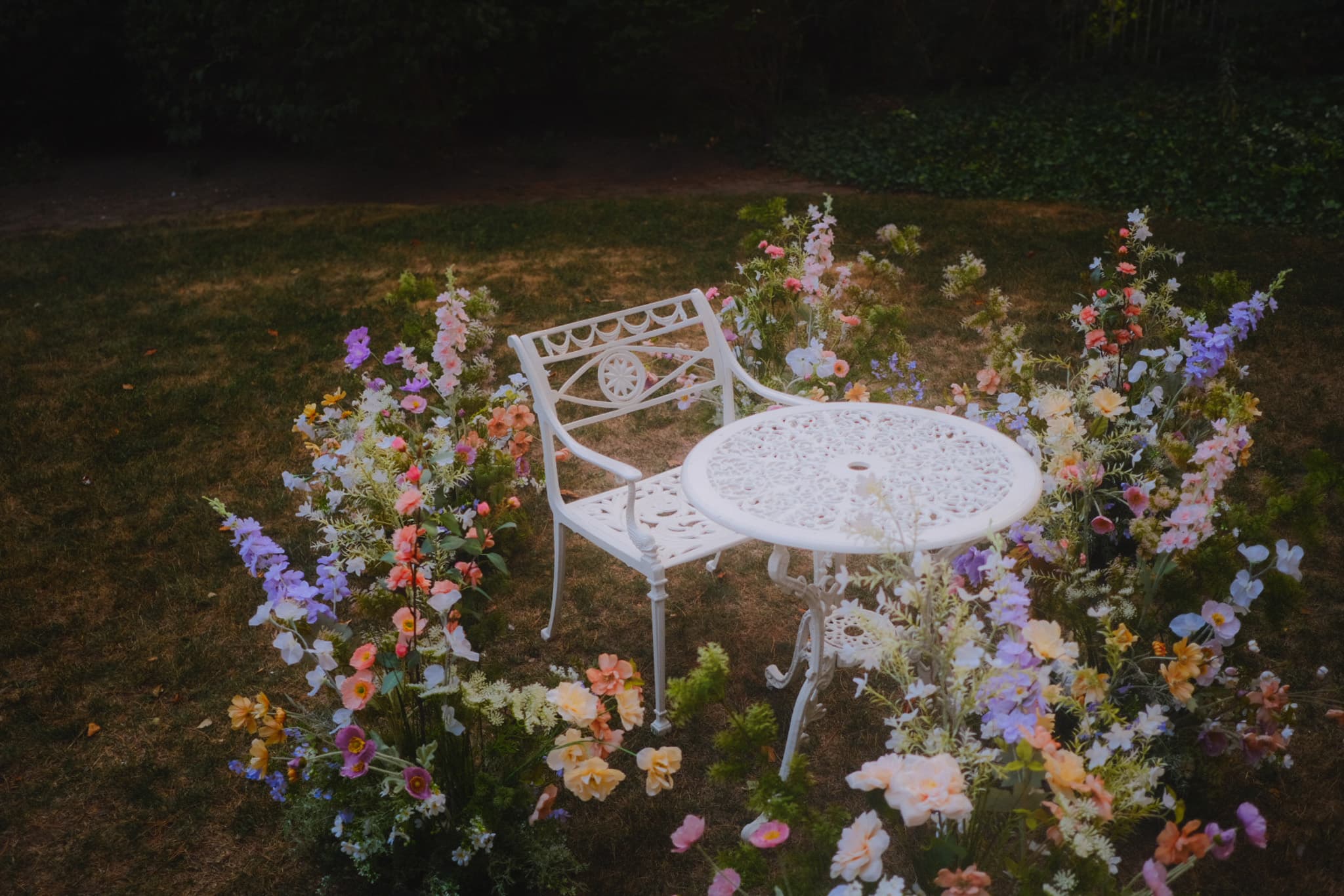 Faux flower markers arranged around a white garden table