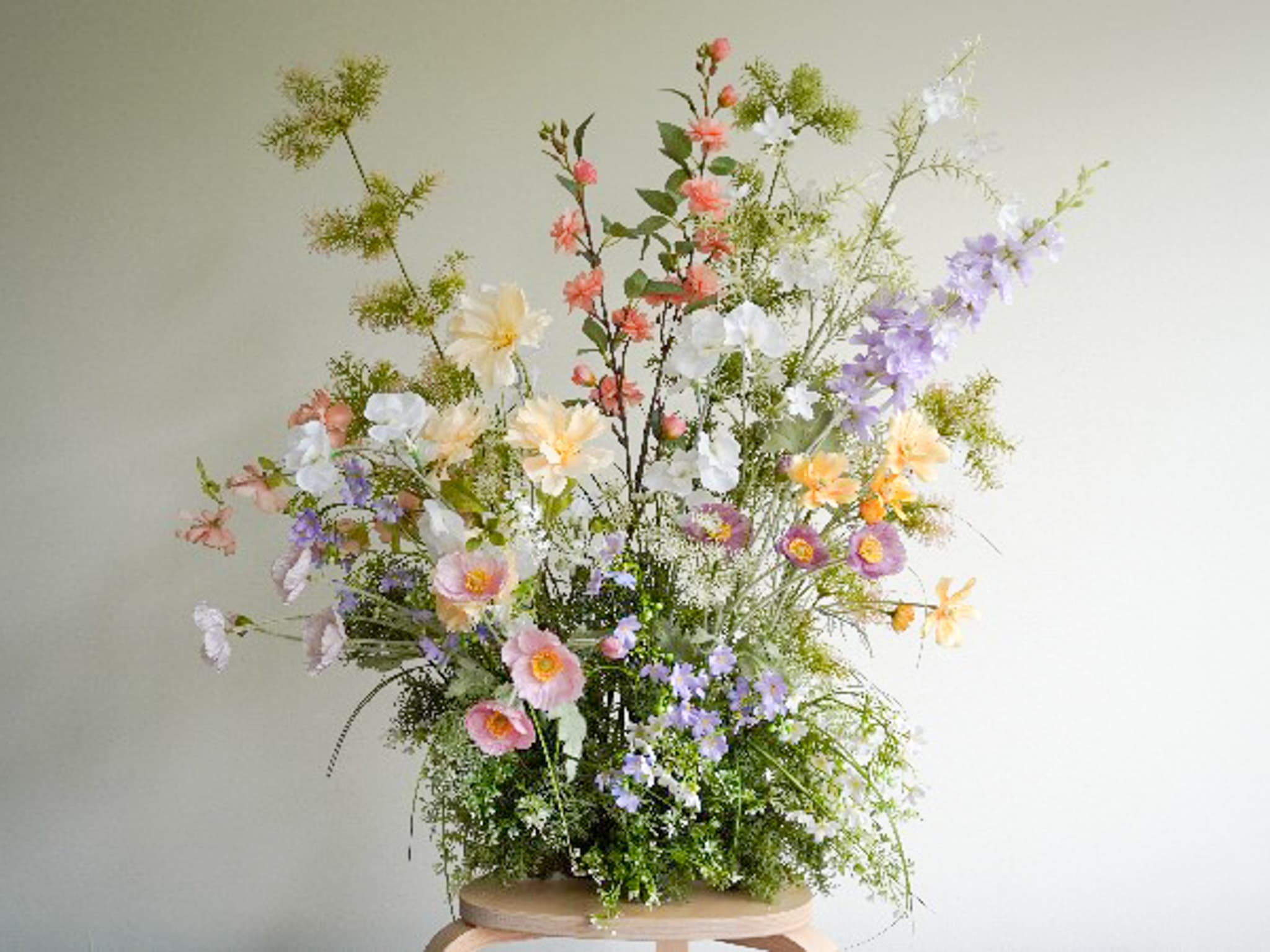 Full faux flower arrangement on a wooden stand